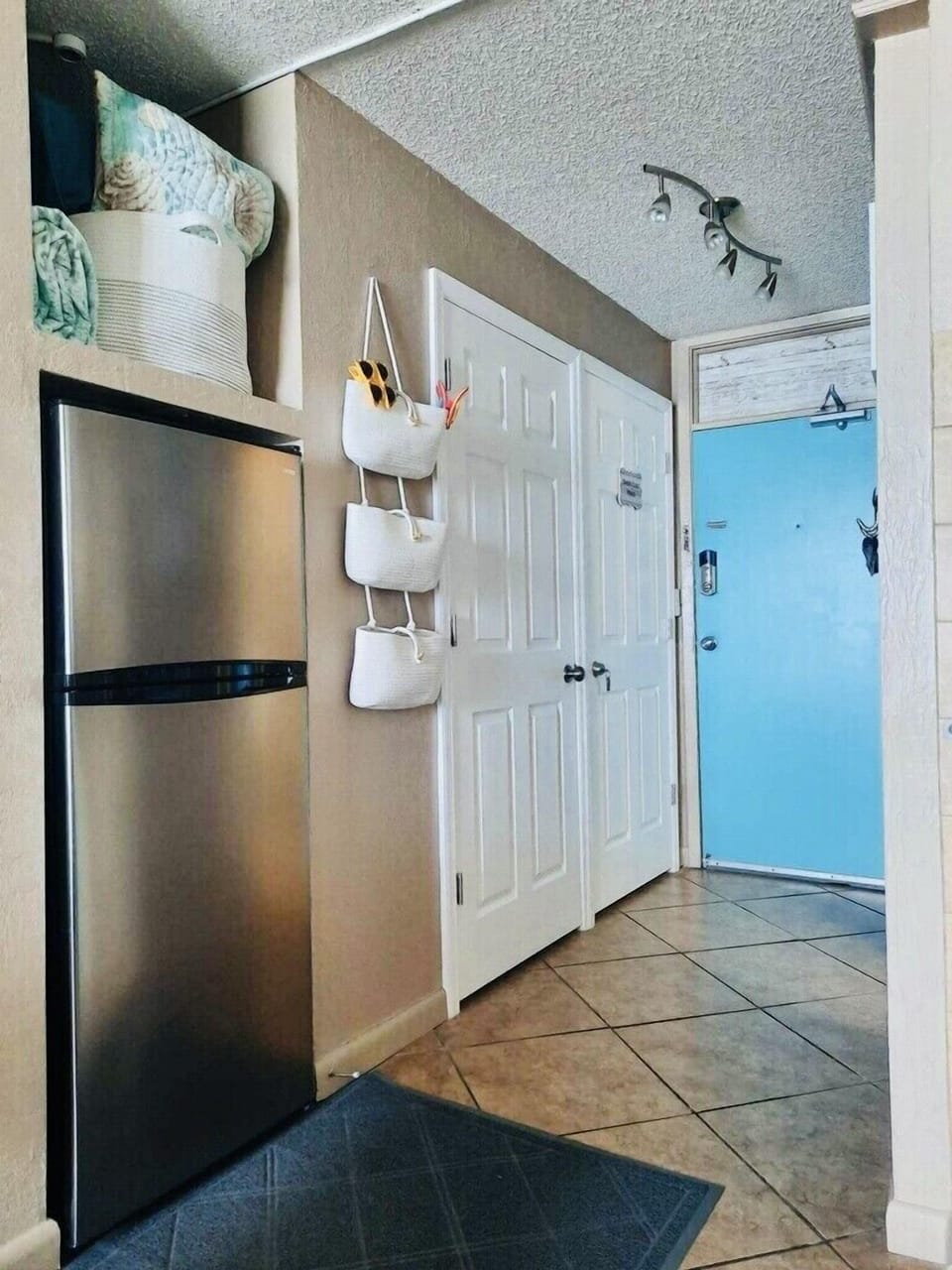 Entry door, guest closet and refrigerator. 