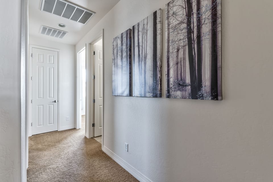 Upstairs hallway connects three bedrooms plus full bath and utility room