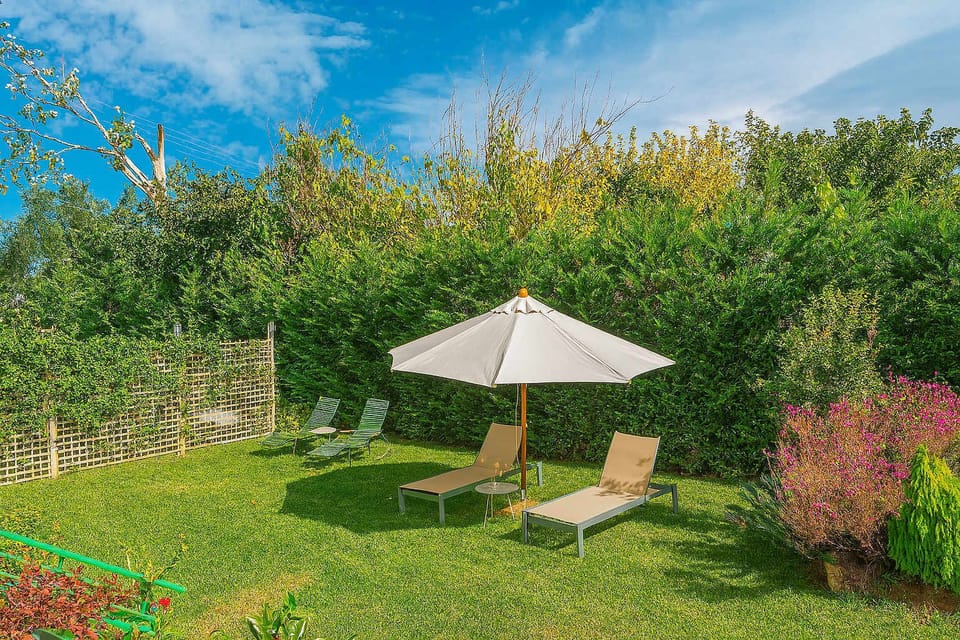 Serene Escape Within the Cozy Garden
A peaceful lawn with sun loungers and umbrella, perfect for unwinding.