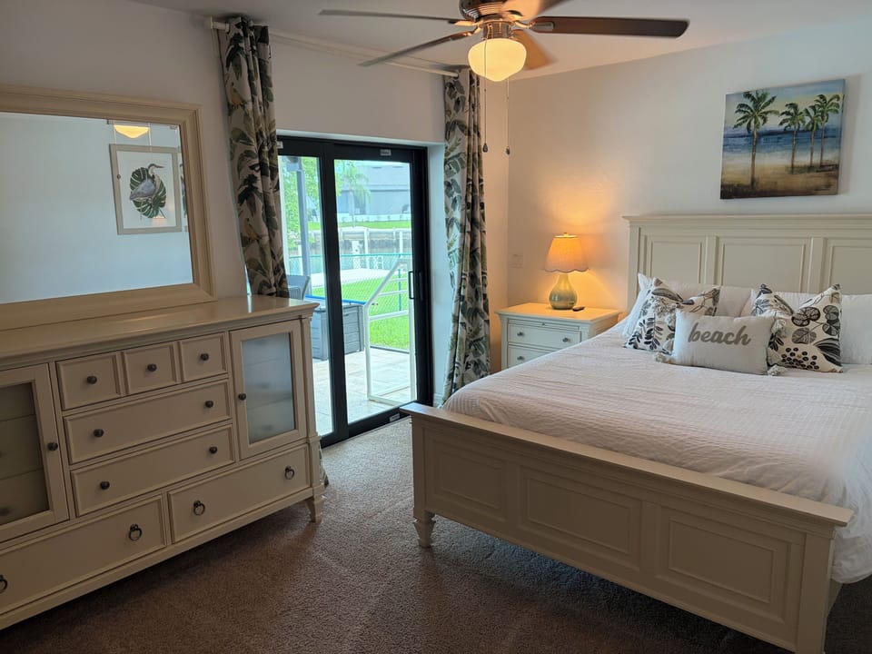 queen bed with sliders to Lanai and pool deck