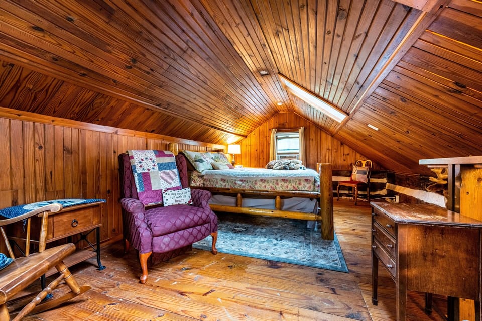 Cozy loft bedroom tucked beneath warm wood ceilings