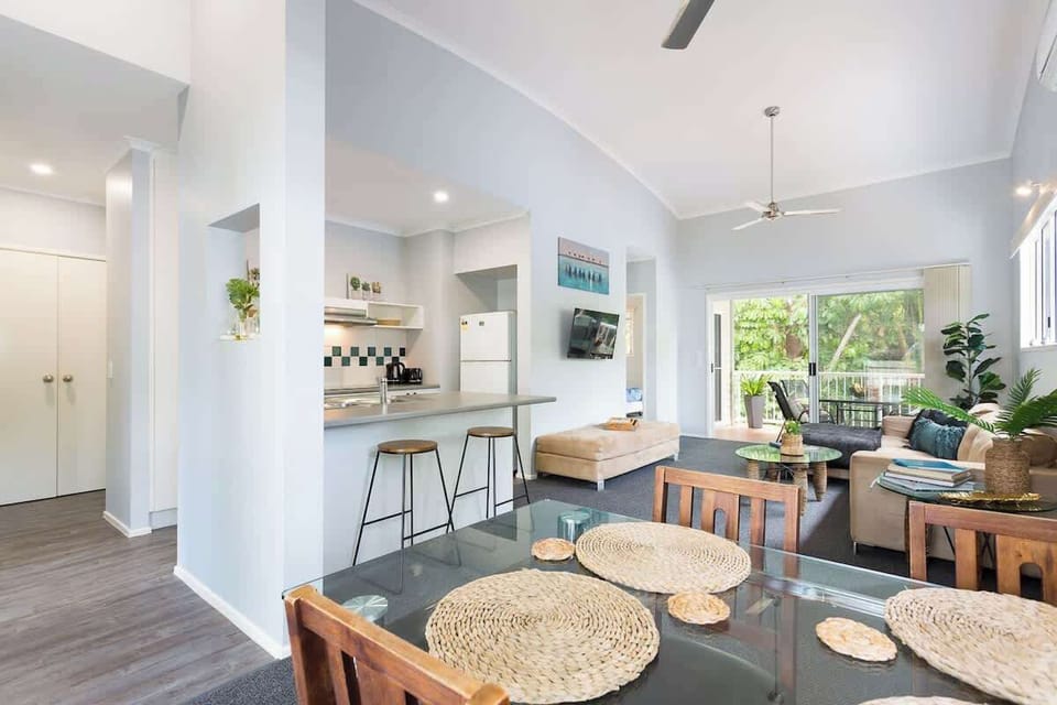 Gather around the dining table for shared meals and relaxed evenings, with the open-plan layout creating an easy flow between kitchen, living, and outdoor spaces.