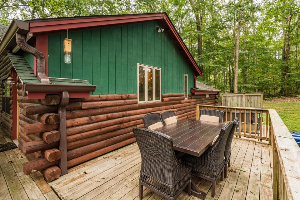 Outdoor dining area with dark wicker chairs and wooden table on the deck