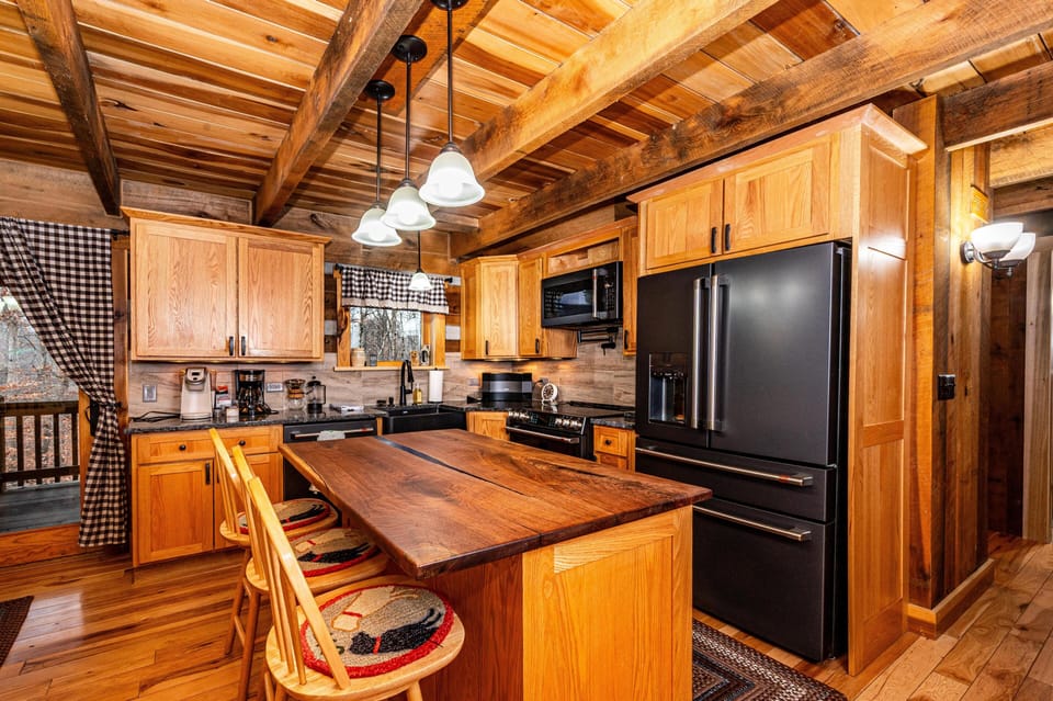 Rustic kitchen with warm wooden beams and breakfast bar seating, perfect for casual mornings and gathering.