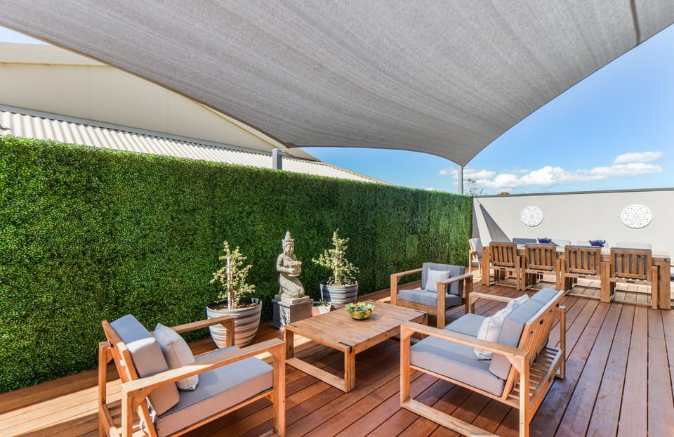 Outdoor area with large dining table, outdoor lounges, party lights and a gas heater