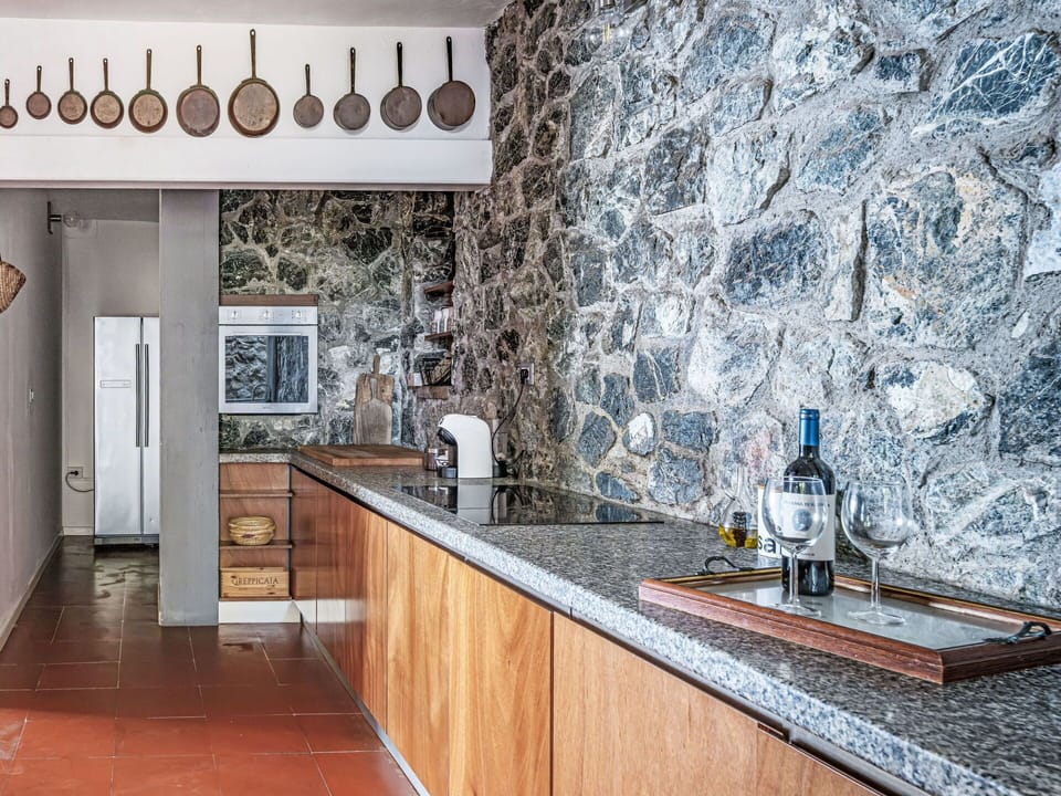Kitchen, Countertop, Ceiling, Natural Material, Cabinetry, Tile, Light Fixture, Plumbing Fixture, Wood Stain, Stone Wall