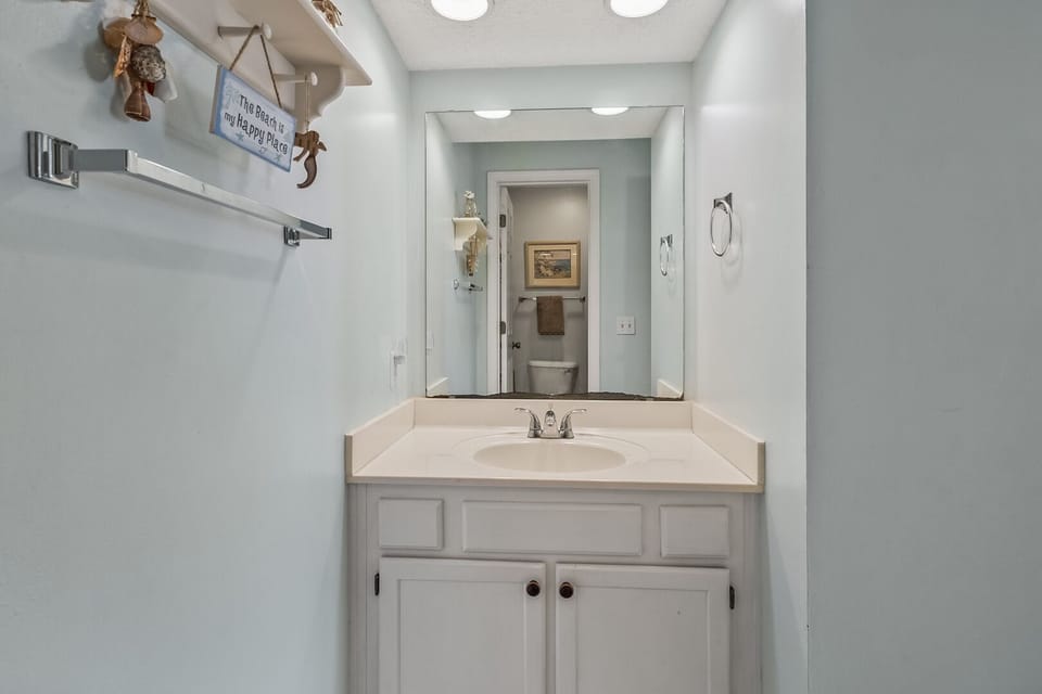 Vanity, mirror and shelving in the bathroom at Tilghman Shores B7, a Cherry Grove vacation rental