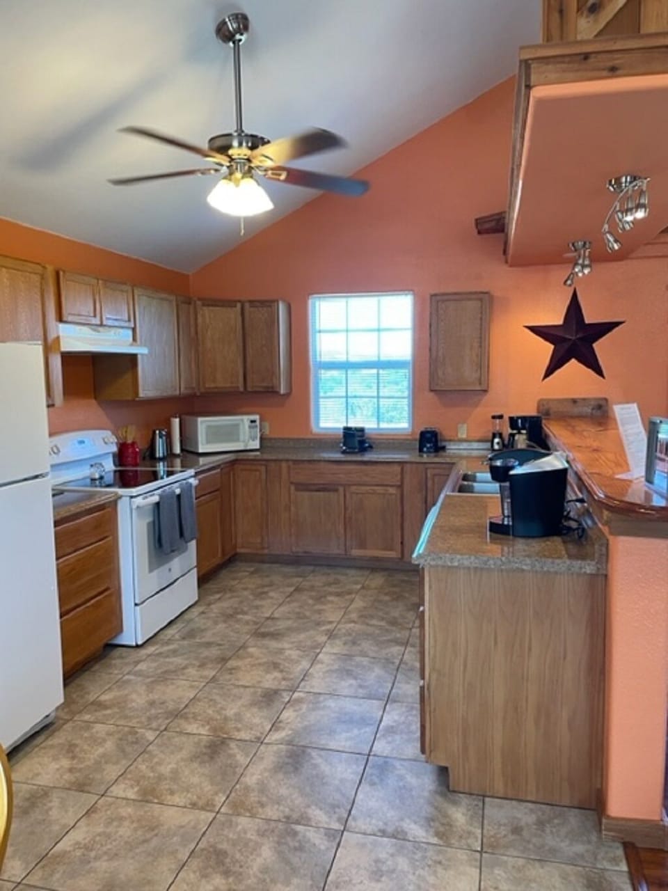 Kitchen has fridge with ice maker, oven, cooktop and dishwasher.