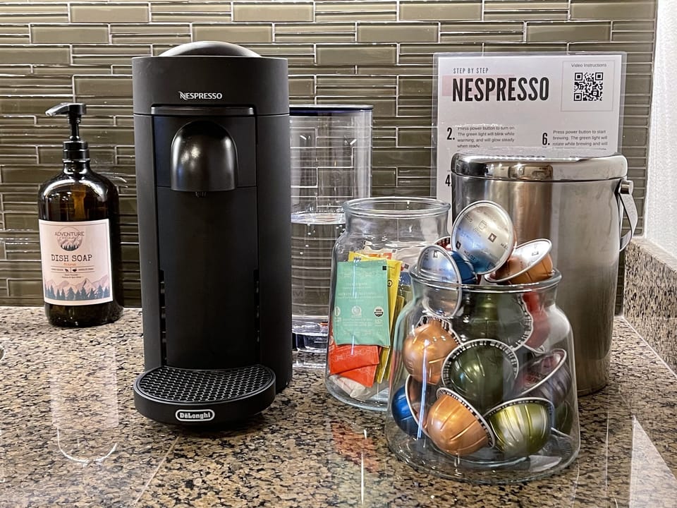 A Nespresso machine anchors the kitchen, complemented by thoughtful extras like a toaster and crockpot for easy mornings and relaxed nights in.