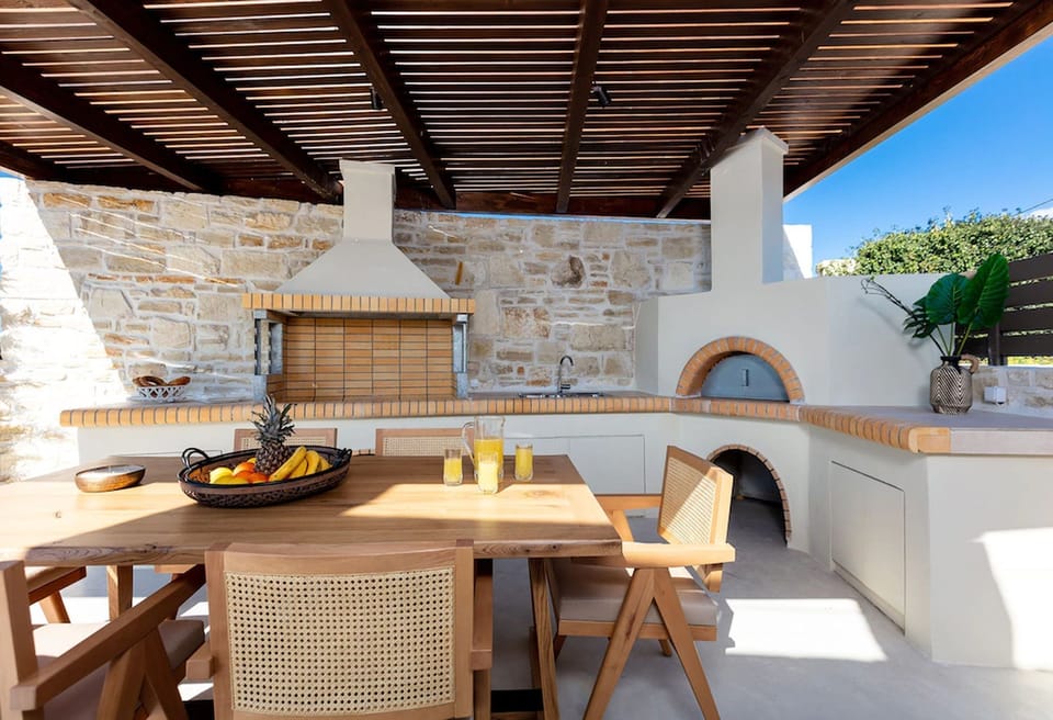 Fully equipped charcoal barbecue area with a sink and a wood oven