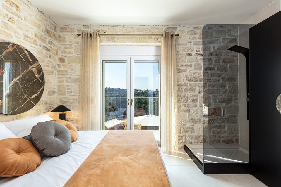Private balcony overlooking the pool area with nature and mountain views.
