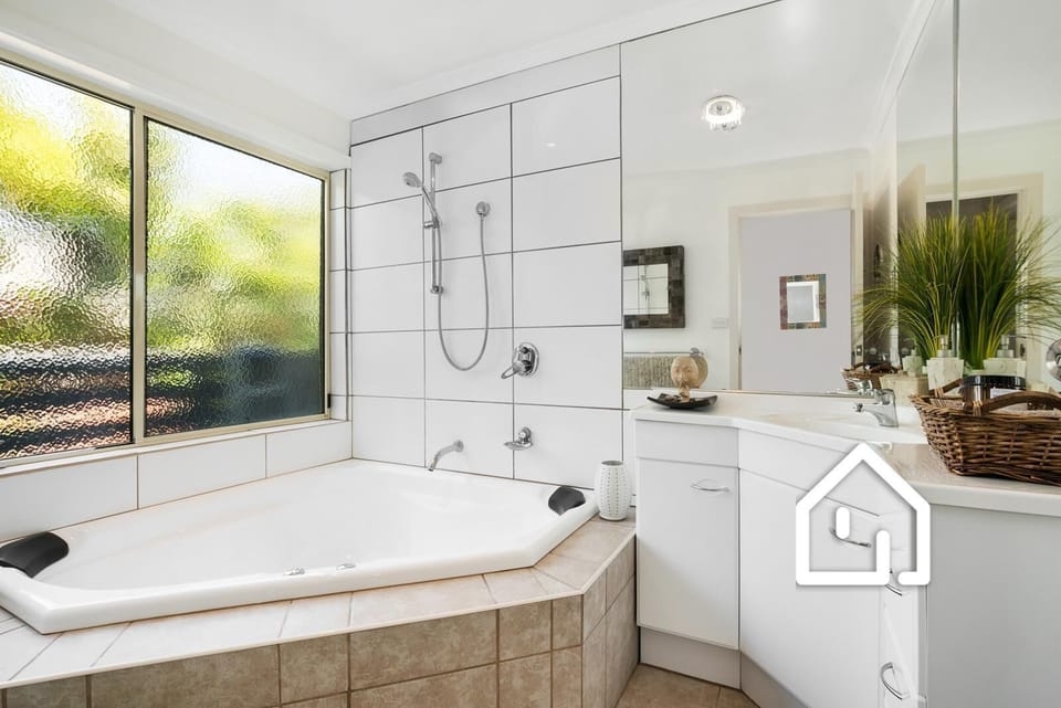 Bathroom with shower over corner spa bath