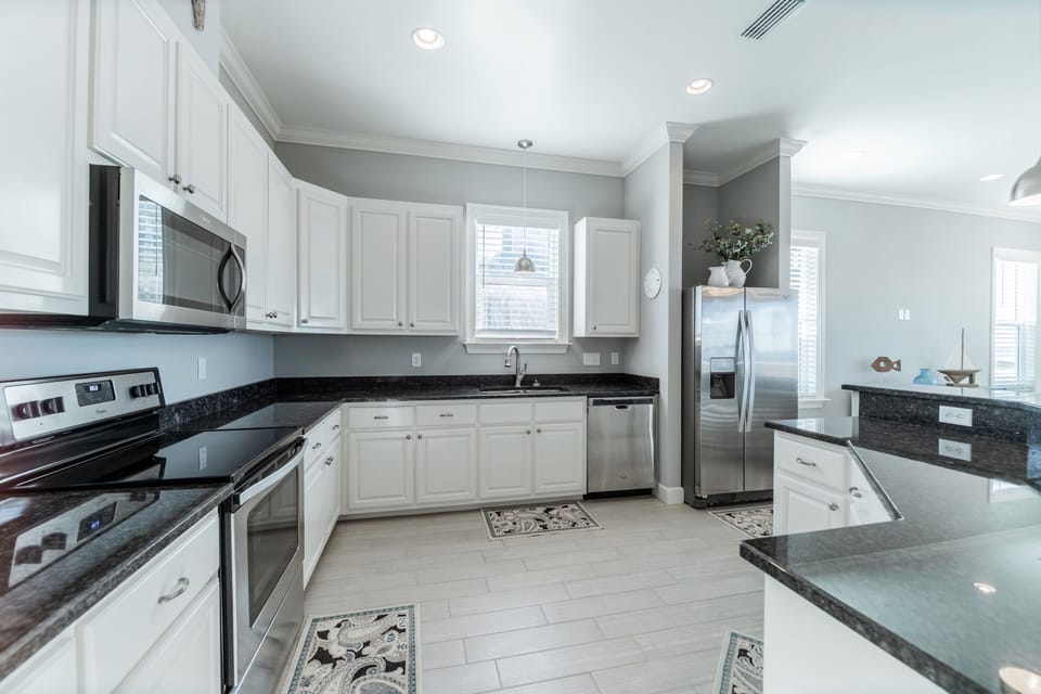 Fully equipped coastal kitchen featuring stainless steel appliances, granite countertops, and ample cabinet space. Perfect for preparing family meals or fresh seafood during your Dauphin Island getaway.