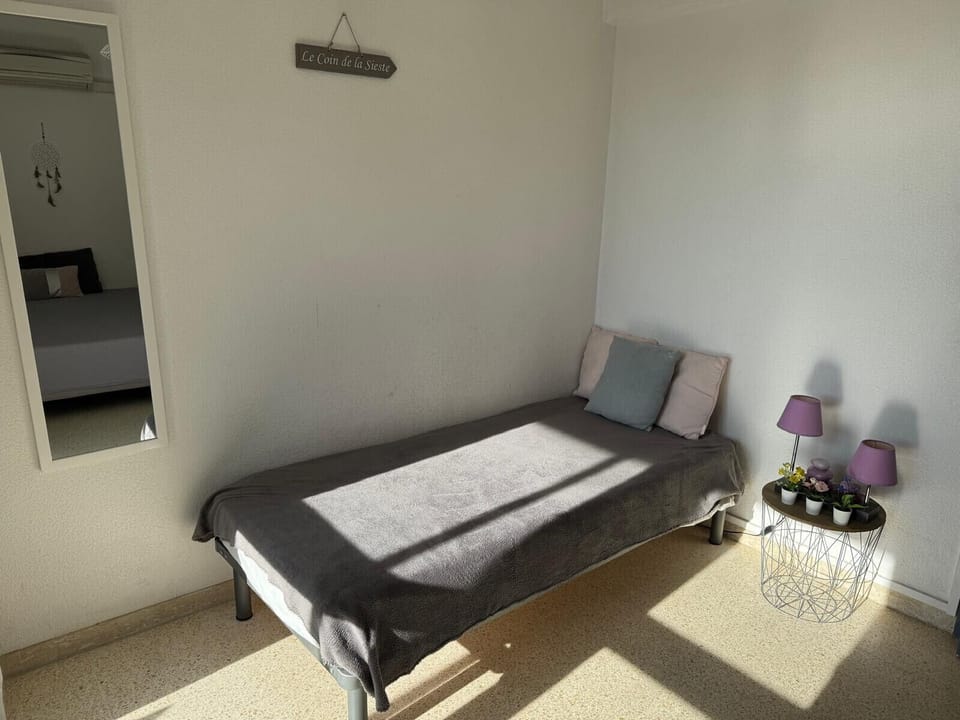 Bright and spacious room, furnished with a double bed and a single bed, offering a pleasant view of a large loggia facing south-east. This room enjoys a beautiful natural light throughout the day. It also has a practical storage cupboard, ideal for optimizing space