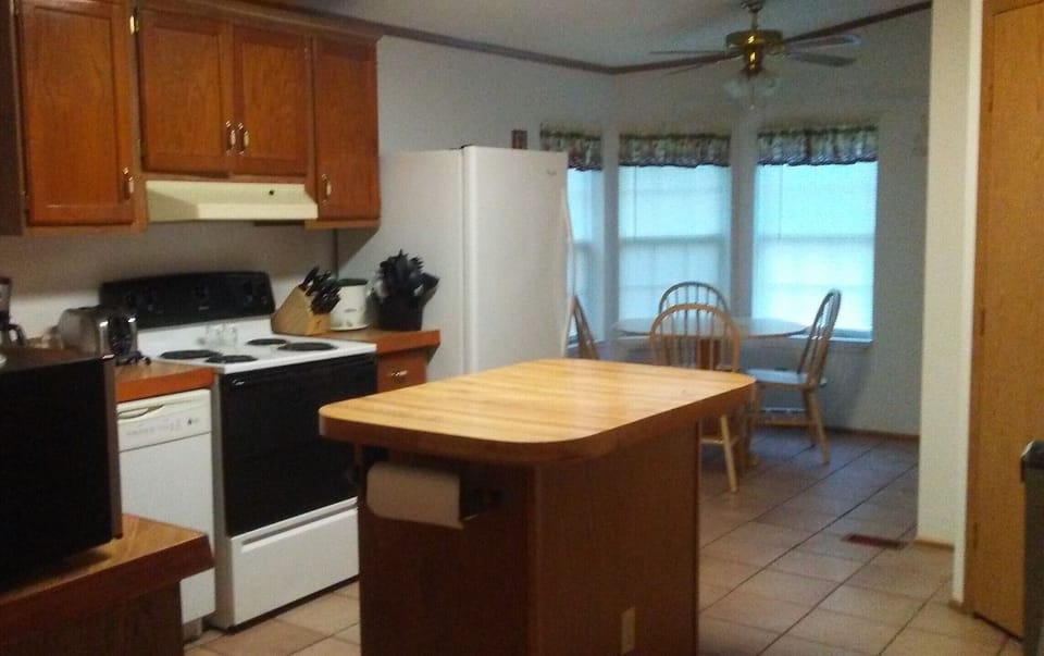 Kitchen with electric stove, refrigerator, dishwasher & microwave.