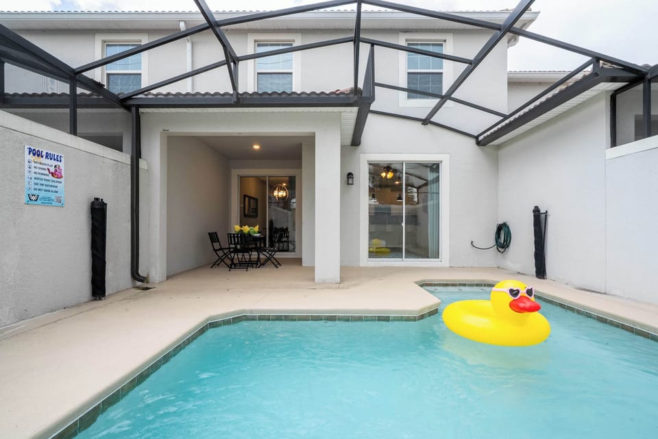 Splash into fun at your private screened pool and patio, complete with a playful giant duck float and cozy outdoor dining-perfect for a relaxing family getaway!