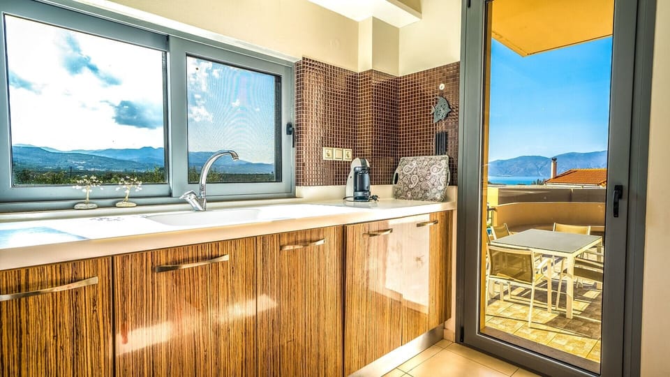 The kitchen offers access to a balcony with dining table.
