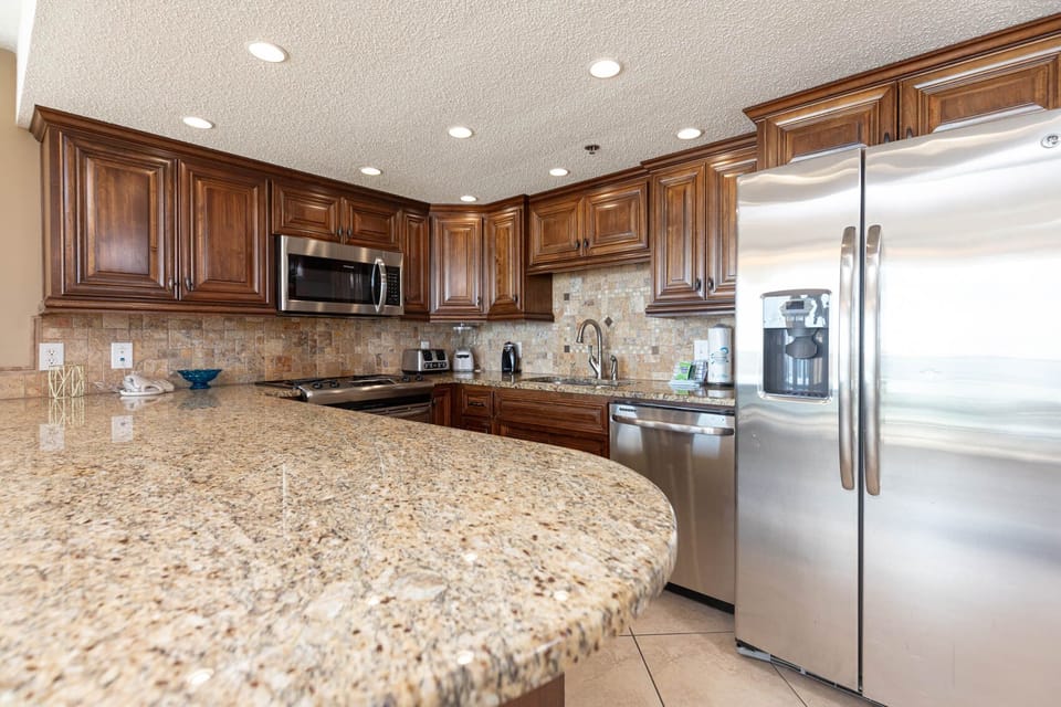The modern kitchen features rich wood cabinetry, stylish countertops, and a breakfast bar, creating an inviting cooking space