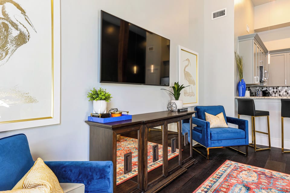 Open-concept living, kitchen, and dining area with ample seating. 65” Samsung Smart 4K TV with streaming and DIRECTV Entertainment. Sofa converts to a queen sleeper. Dining table seats four. Enjoy plenty of natural light!