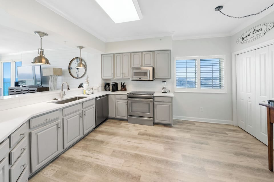 Your spacious kitchen features modern appliances, quartz countertops, and natural light flooding through the skylight—perfect for preparing memorable meals.