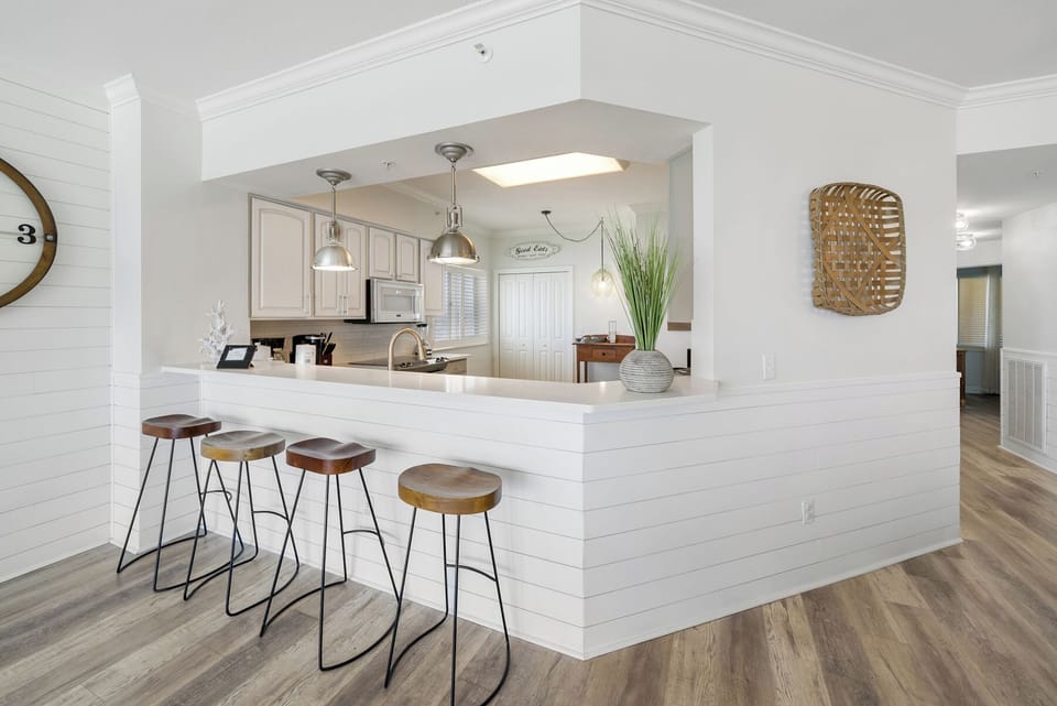 Your modern kitchen island invites morning coffee conversations with stylish seating and elegant pendant lighting overhead.