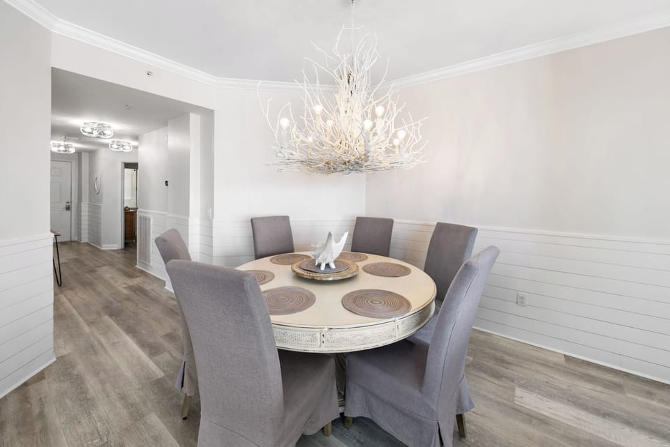 Gather around your elegant dining table beneath the stunning chandelier for memorable meals in this beautifully appointed space.