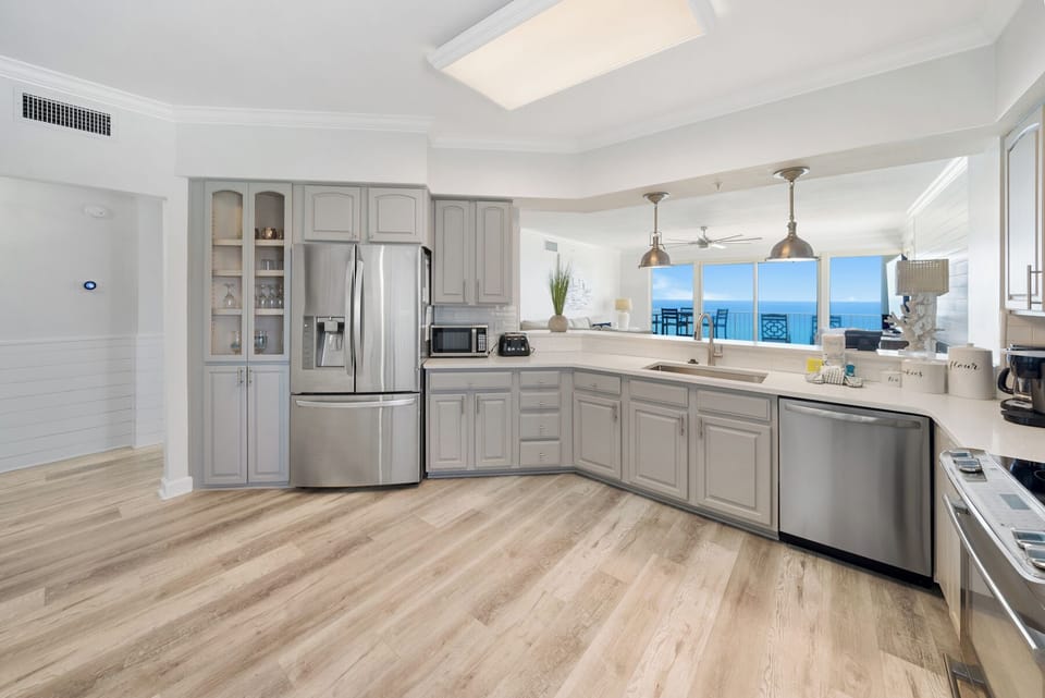 Your gourmet kitchen features gleaming stainless steel appliances and stunning ocean views that'll inspire your morning coffee routine.