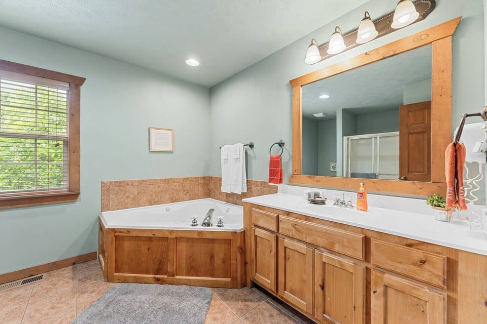 Master bath #1, has a large vanity and a jacuzzi tub with its own standalone shower unit
