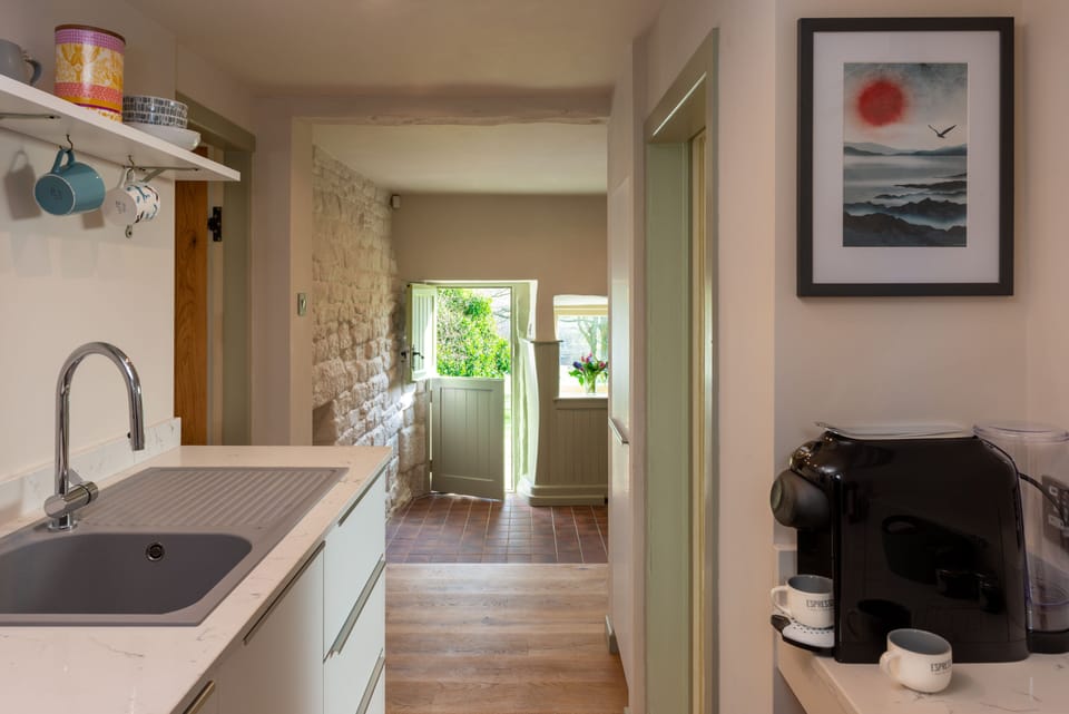 Looking from the kitchen to the entrance with stable door and painted stone wall