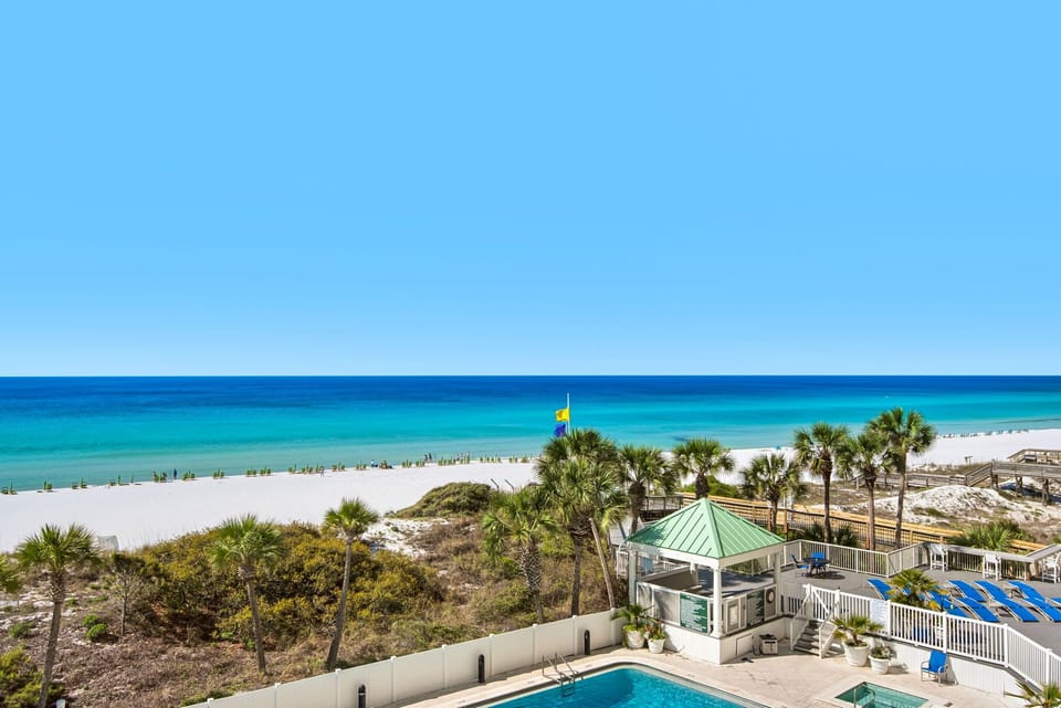 Stunning beachfront property with pristine white sand beach and crystal-clear turquoise waters stretching to the horizon.