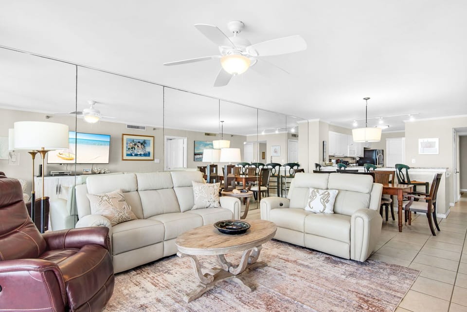 Relax in your spacious open-concept living area, where comfortable seating and coastal decor create the perfect atmosphere for family gatherings and peaceful evenings.