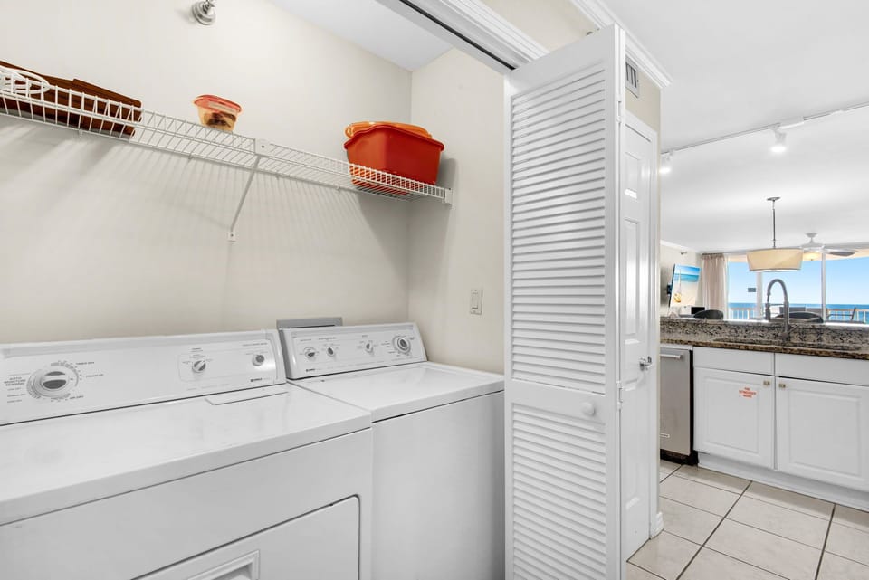 Your dedicated laundry space with full-size washer and dryer keeps you refreshed while the ocean view kitchen beckons nearby.