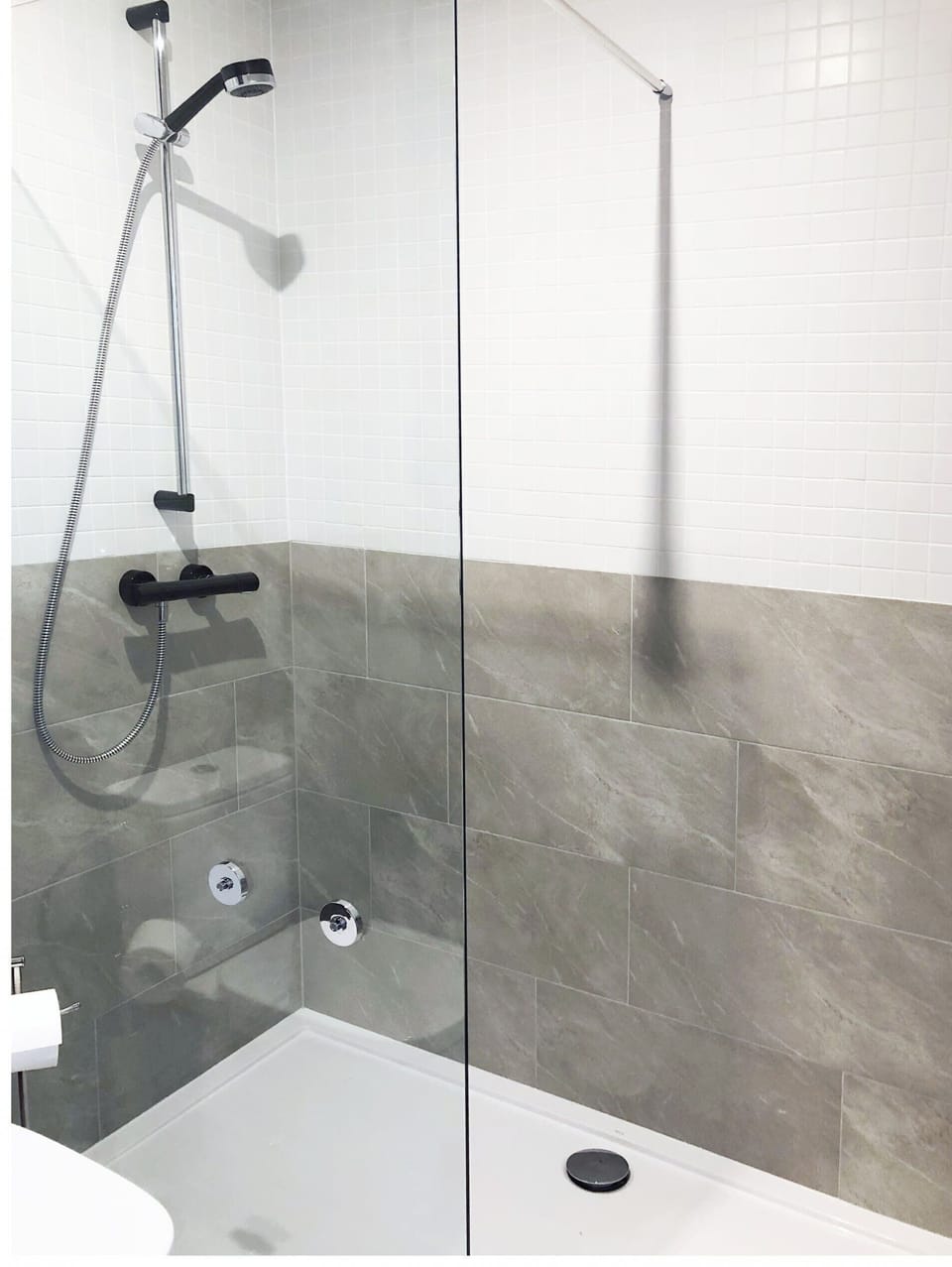 Bright bathroom with washing machine and shower cabin. 