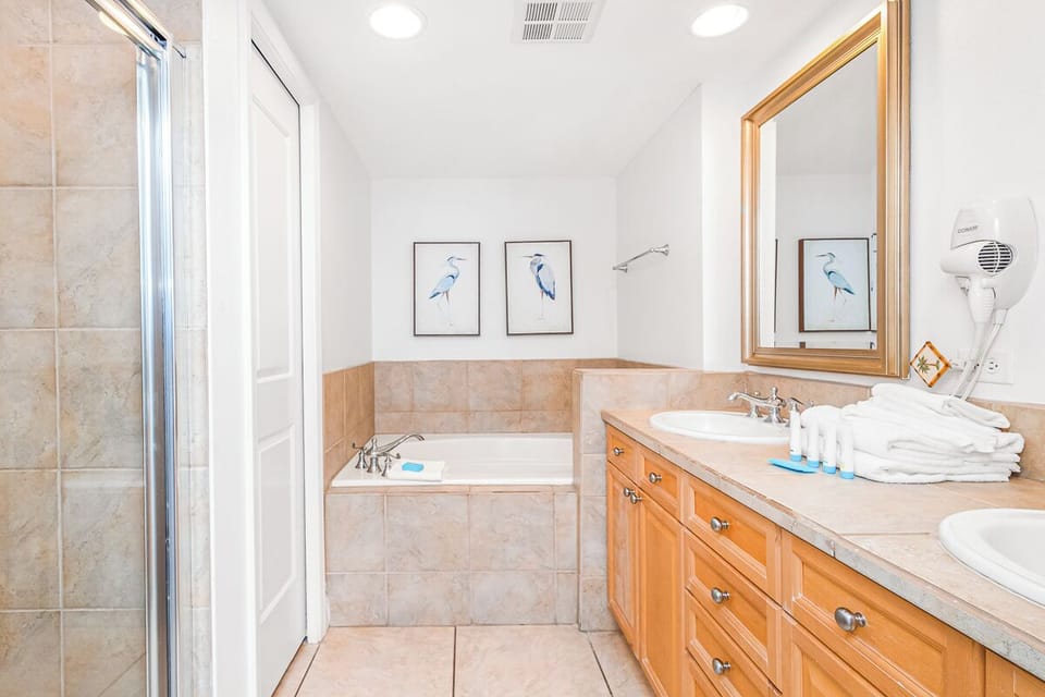 Unwind in your spacious bathroom with marble details, soaking tub, and plush towels awaiting your arrival.
