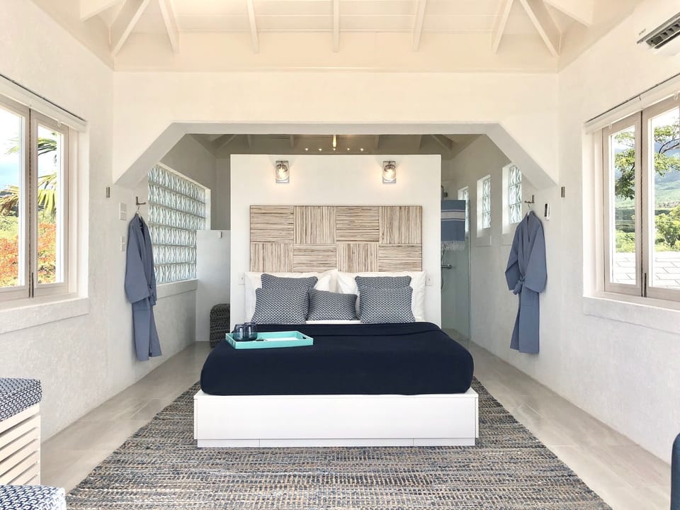 The queen size bed from the main bedroom. The bathroom is behind the bed wall.