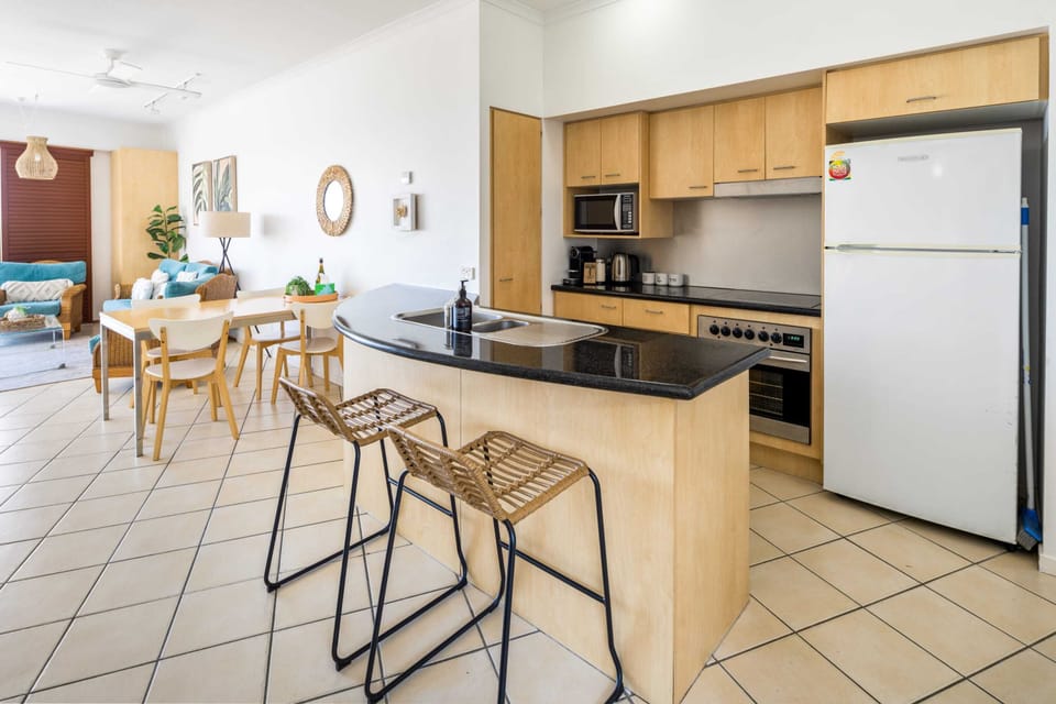 Open plan kitchen, dining, and living that opens onto a balcony