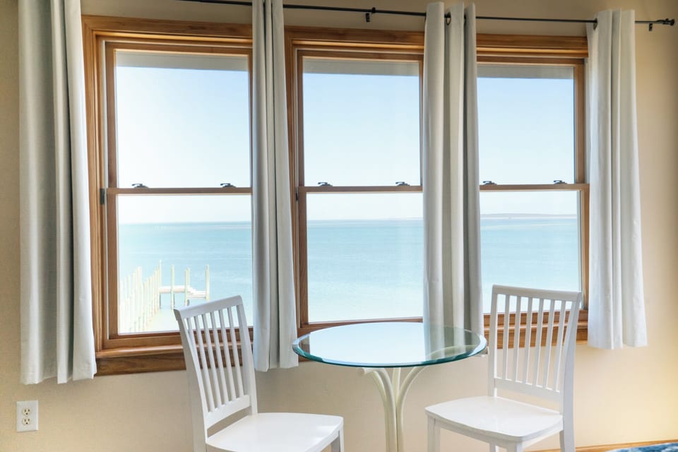 Step inside and lose yourself in stunning waterfront views framed by bright windows. Your private table awaits, where morning coffee or evening wine tastes better with serene blue horizons stretching endlessly before you.