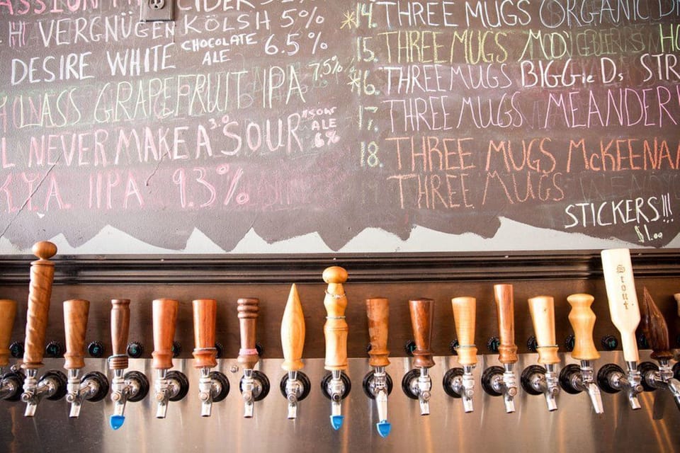 Taproom bar with draft taps and chalkboard beer menu.