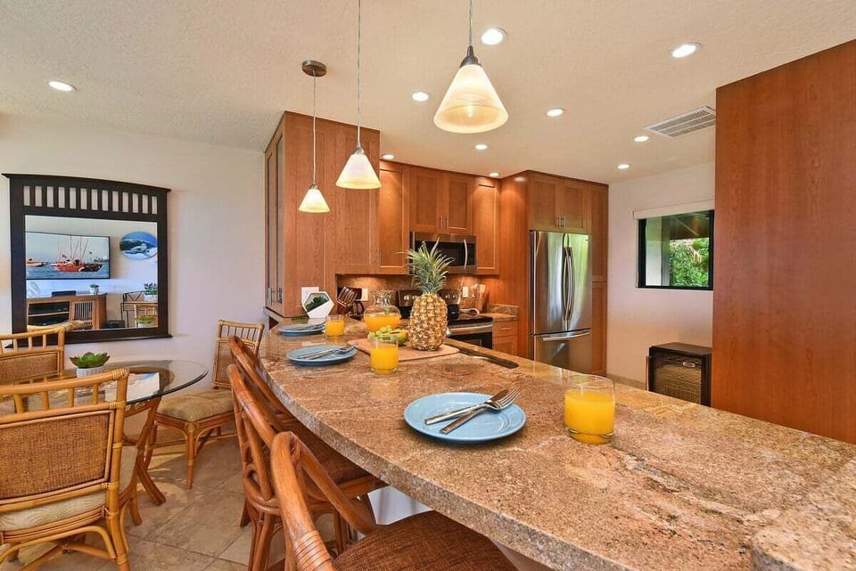 Fully equipped cooking area featuring updated appliances and a stylish breakfast bar