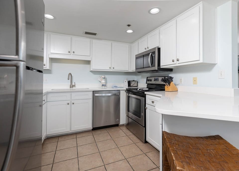 Prepare meals in this bright kitchen featuring stainless appliances, ample counter space, and stylish cabinetry