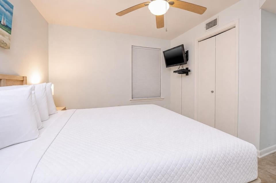 Relax in the comfortable bedroom featuring a king-sized bed, a TV, and soft lighting for a restful retreat
