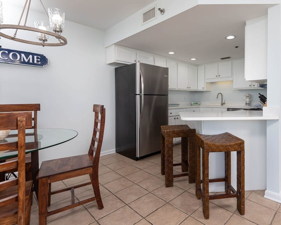Gather around the glass dining table with wooden chairs, enjoying the inviting kitchen space and cozy decor