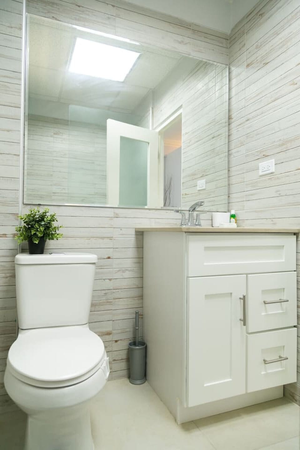 Clean bathroom w/ tiled shower, sink vanity & simple modern finishes