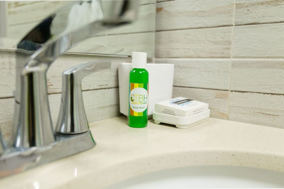 Fresh bathroom space w/ large mirror, sink & textured tile walls