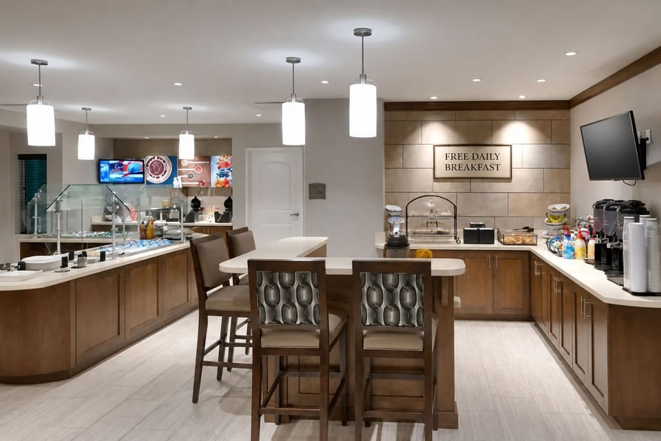 Breakfast bar area with bar stools, pendant lighting, and coffee station.