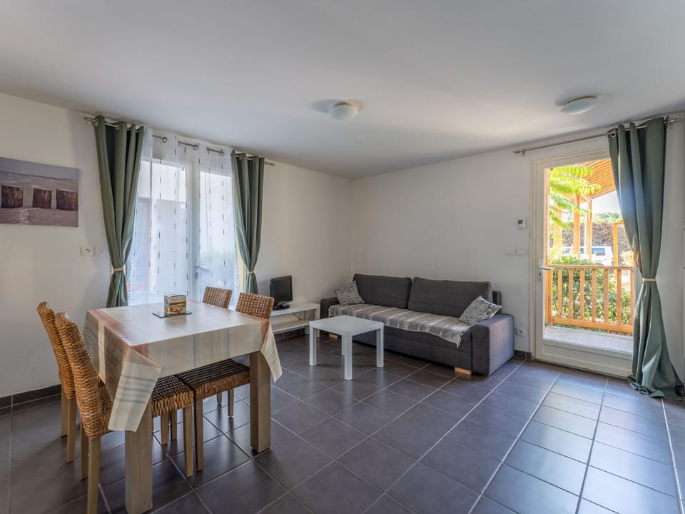 The bright open living and dining space, with a sofa bed to comfortably sleep four and easy access to the terrace beyond.