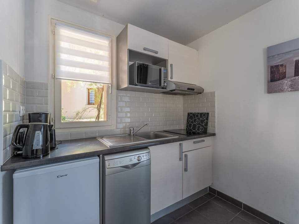 The fully equipped kitchenette — ceramic hob, microwave, dishwasher, coffee maker and more — everything you need to settle in and stay a while.