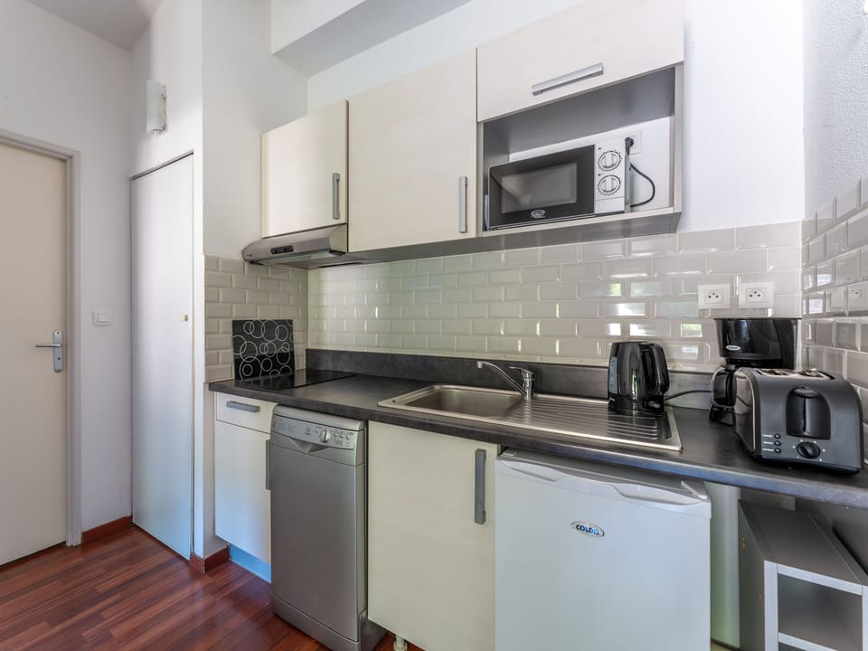 The well-equipped kitchenette with ceramic hob, microwave and dishwasher — all you need to settle in and enjoy the rhythm of lake life at Les Rives du Lac.