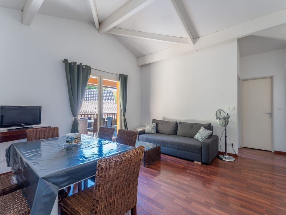 The warm, characterful living and dining area of this triplex apartment, where rich timber floors and open-plan layout create a welcoming space for the whole group.
