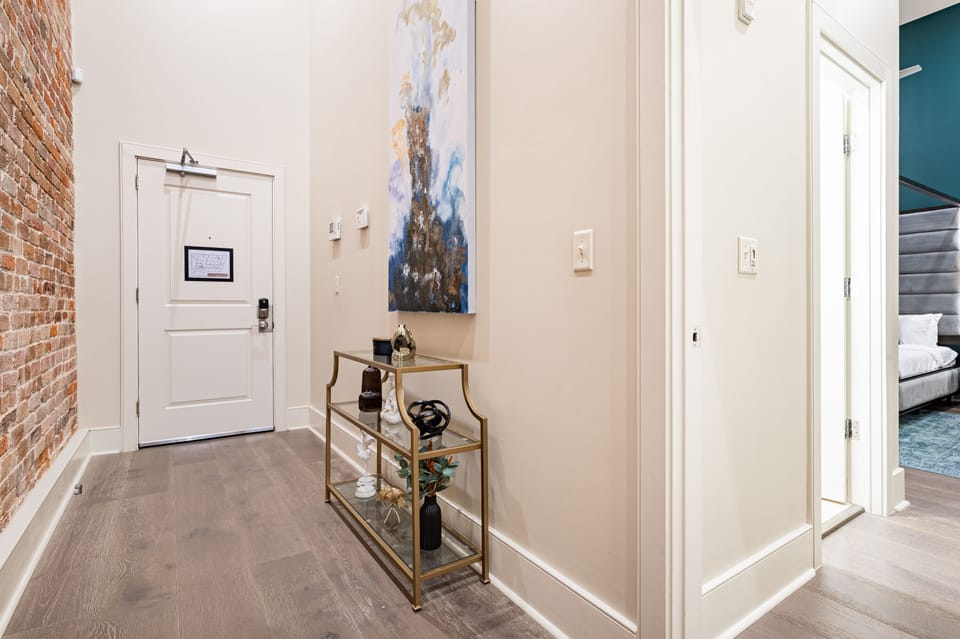 Entry way featuring high ceilings and exposed brick.